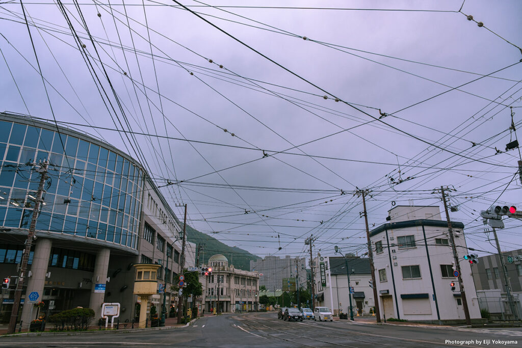 道路には市電が走り、頭上には無秩序に張り巡らされた電線。昭和の地方都市のようで、郷愁そそります。